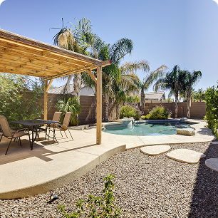 Image of tropical trees in a yard with a pool and gazebo.